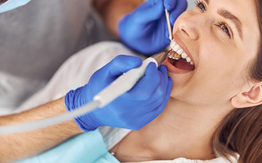 mujer realizándose una limpieza dental profesional