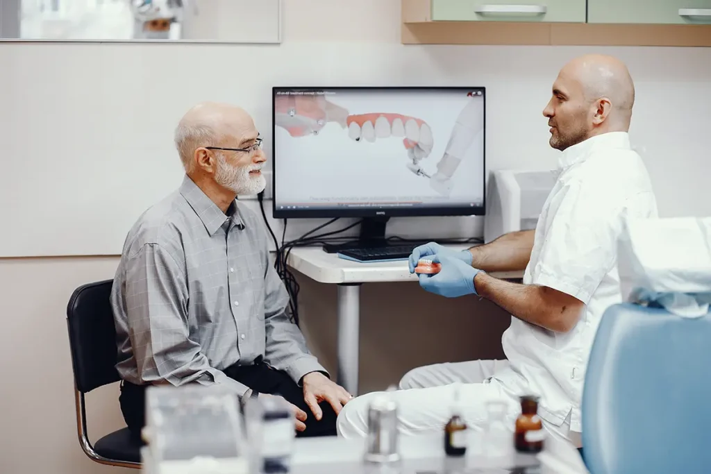 dentista explicando la diferencia entre implantes y puentes dentales