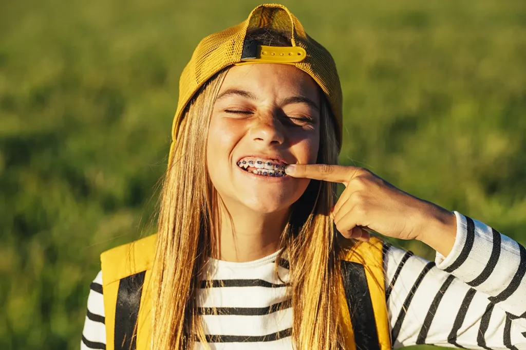 niña señalándose los brackets al sol
