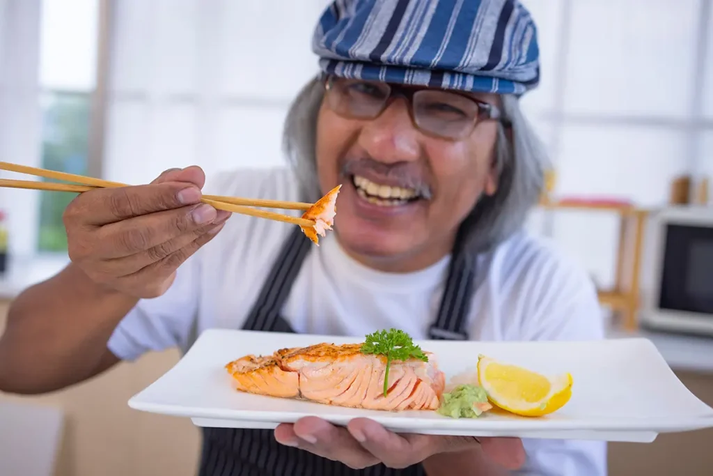 hombre comiendo salmón para cuidar sus dientes en verano