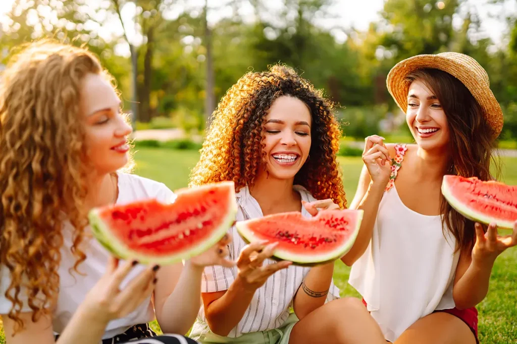 mujeres comiendo sandía para cuidar sus dientes en verano